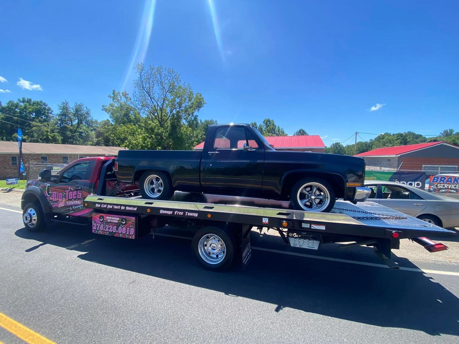 Big Toe's flatbed carrying a classic black Chevy pickup